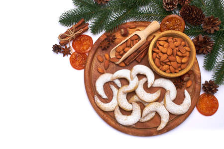 German or Austrian Vanillekipferl vanilla kipferl cookies and almond nuts on wooden serving boardの写真素材