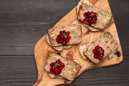 Sliced Traditional French terrine covered with bacon on dark wooden background