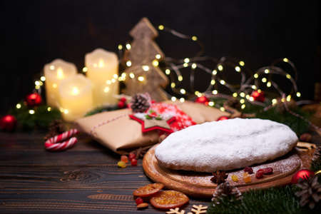 Traditional Christmas stollen cake and New Year decorations on wooden backgroundの写真素材