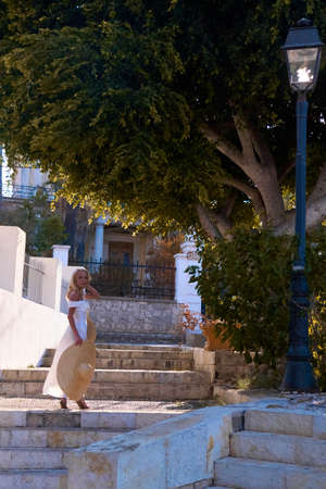 Woman tourist walking the streets of a old Greek cityの写真素材