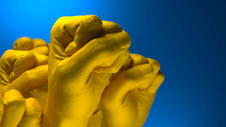 Fist in colors of Ukrainian Flag raised to fight and resist russian agressionの写真素材