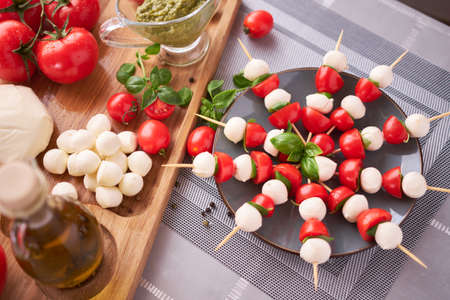 Caprese salad - Mini mozzarella cheese in glass bowl, tomato and basilの写真素材