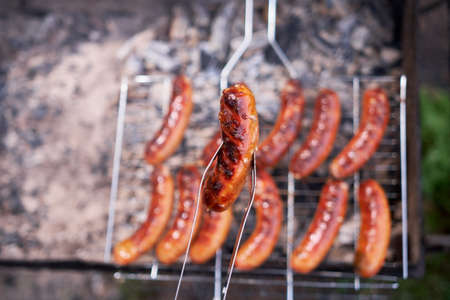 Tasty Sausages grilling on charcoal grill grateの写真素材