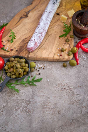 Spanish sausage fuet salami and vegetables on a domestic kitchenの写真素材