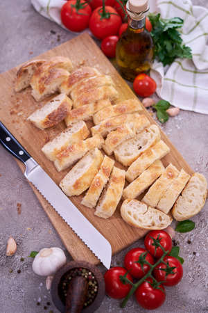 Sliced French bread baguette on wooden bread board
