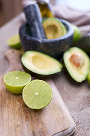 making guacamole - fresh sliced avocado in marble mortar on grey concrete tableの写真素材