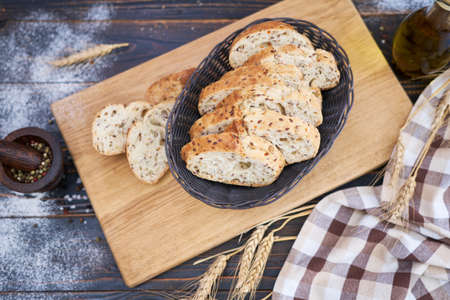 Fresh sliced bread on wooden cutting board at kitchen tableの写真素材