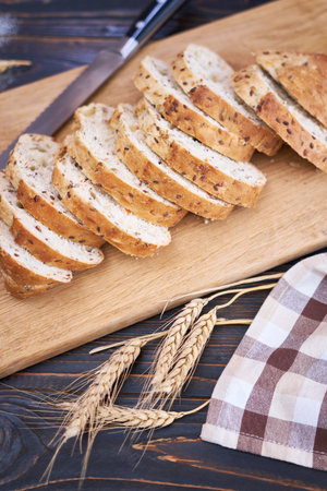 Fresh sliced bread on wooden cutting board at kitchen table