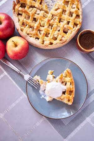 Piece of Fresh homemade Traditional Apple Pie with ice cream on a domestic kitchenの写真素材