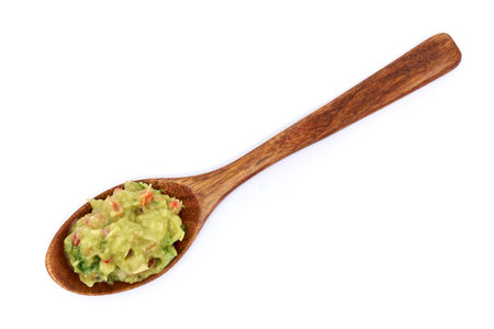 Spoon full of guacamole Mexican dip sauce isolated on white backgroundの写真素材