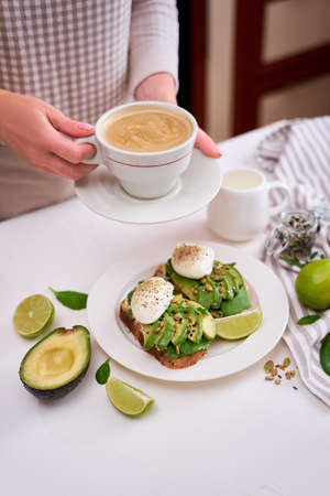 Freshly made poached egg and Avocado toasts on light grey background