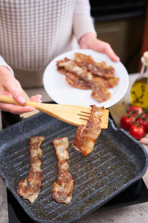 Bacon Being Cooked in grill frying pan Skillet at domestic kitchenの写真素材