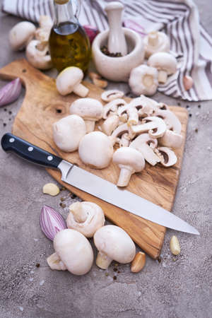 champignon mushrooms on wooden cutting board at domestic kitchenの写真素材