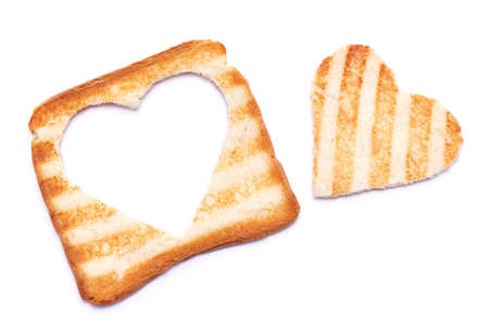 Toasted bread with grill marks and heart shaped hole isolated on white backgroundの写真素材