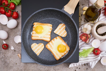 Heart shaped Fried Egg on Toast Bread in a pan at domestic kitchen