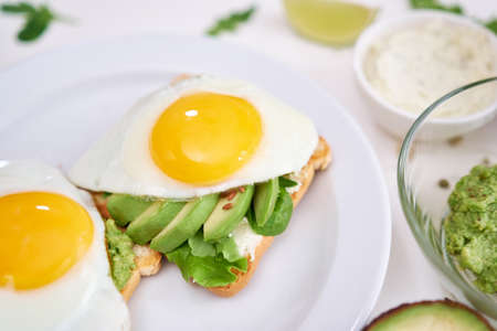healthy breakfast or snack - sliced avocado and fried egg on toasted breadの写真素材