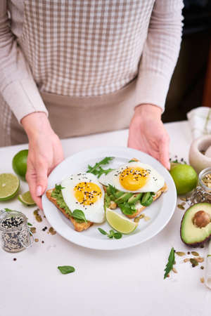 healthy breakfast or snack - sliced avocado and fried egg on toasted breadの写真素材