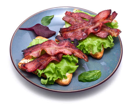 bacon and cream cheese sandwiches on a plate isolated on white background