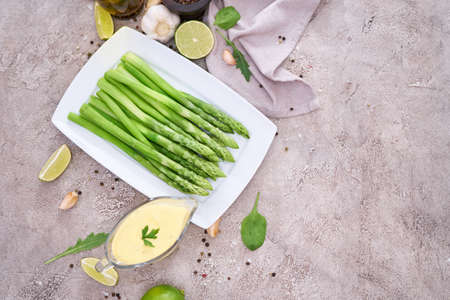 Green organic natural Asparagus in ceramic white plate on kitchen tableの写真素材