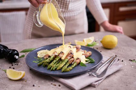Healthy food - Asparagus wrapped with bacon and spices on a plateの写真素材