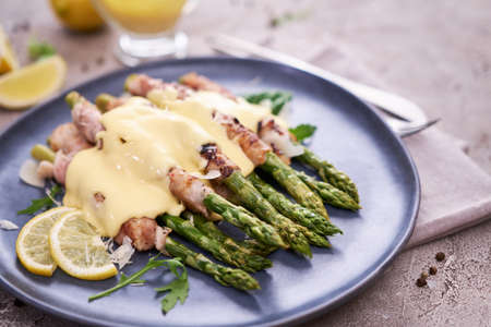 Healthy food - Asparagus wrapped with bacon and spices on a plateの写真素材