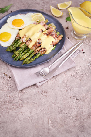 Healthy tasty breakfast - Asparagus wrapped with bacon and fried eggs on a plateの写真素材