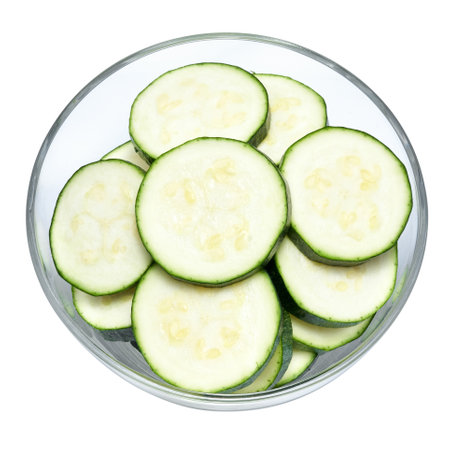 Sliced zucchini circles in glass bowl isolated on white backgroundの写真素材