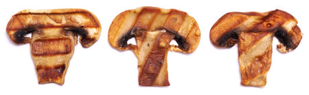 Grilled Slices of champignon mushrooms with stripes from a grill isolated on white backgroundの写真素材
