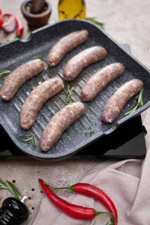 Grilled sausages on a grill frying pan on a domestic kitchenの写真素材