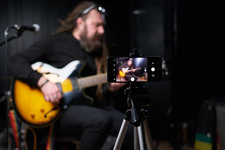 Guitarist man plays an electric guitar Close-up at studio