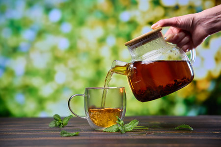 natural organic herbal tea pours in a glass from glass teapotの写真素材
