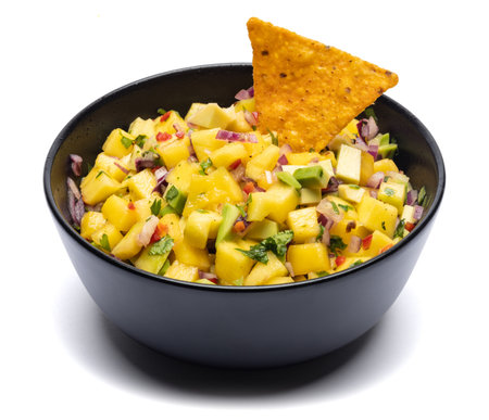 Freshly made mango salsa in a black ceramic bowlの写真素材
