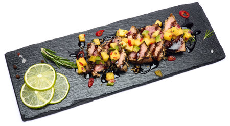 Sliced Organic grilled Tuna fillet covered with sesame seeds on black stone serving boardの写真素材