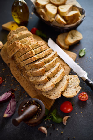 sliced bread on wooden cutting board on dark tableの写真素材