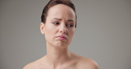 Beauty, health, cosmetics, anti-aging therapy and skin care concept - young beautiful brunette Caucasian woman in a bad mood, upset and disappointed experiencing negative emotionsの写真素材