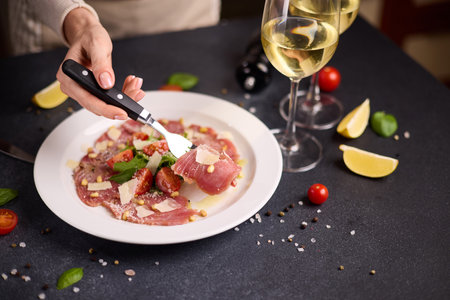 cooking tuna carpaccio - cherry tomato pieces on a plate with raw tuna fillet slicesの写真素材