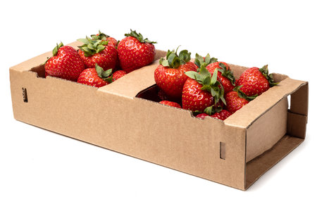 Healthy food and ingredients - Cardboard box full of natural organic ripe strawberries isolated on white background with built-in cutout outlineの写真素材