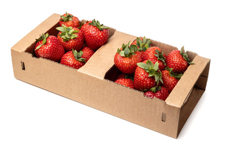 Healthy food and ingredients - Cardboard box full of natural organic ripe strawberries isolated on white background with built-in cutout outlineの写真素材
