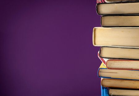 A pile of old books on a colored backgruond