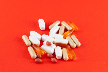 Various pills of supplement on colored background