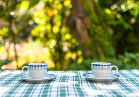 Two little cups of coffee on a table in a gardenの写真素材