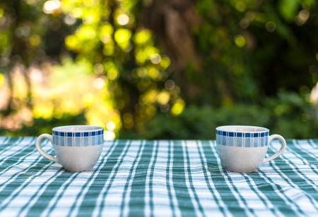 Two little cups of coffee on a table in a gardenの写真素材
