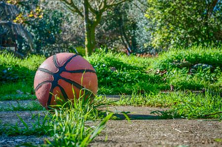 Used basketball in country playground in a sunny morningの写真素材