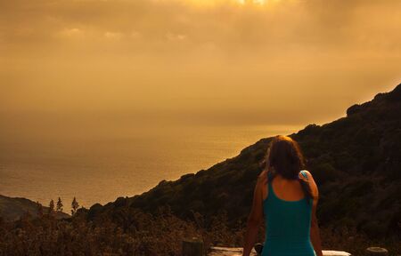 a girl who looks at the landscape with a sunset fairytaleの写真素材
