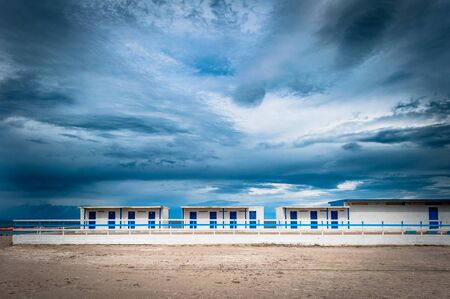 White and blue building on the beach under a dramatic cloudy day of autumn - Platamona - Sardinia - Italyの写真素材