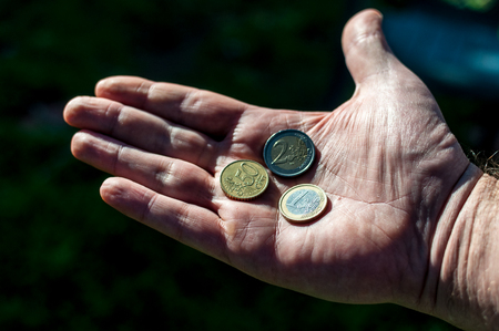 Closeup of big hand with euro coinsの写真素材