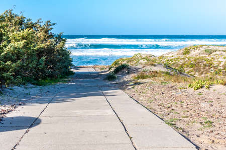Beach with rough sea and waves in a sunny day of winterの写真素材