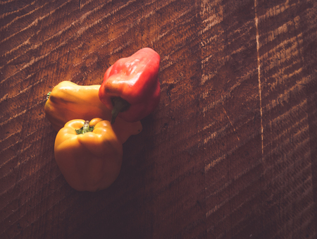 colored peppers on wooden table with copy spaceの写真素材
