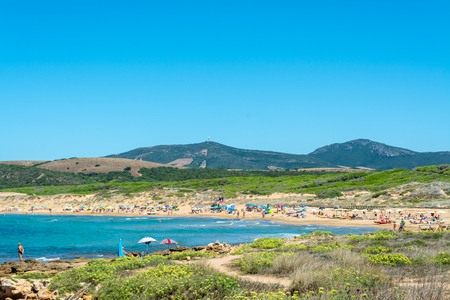 Landscape of the crowded sardinian beach of Porto Ferro in summerの写真素材