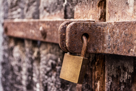 detail of a padlock on a very old wooden doorの写真素材